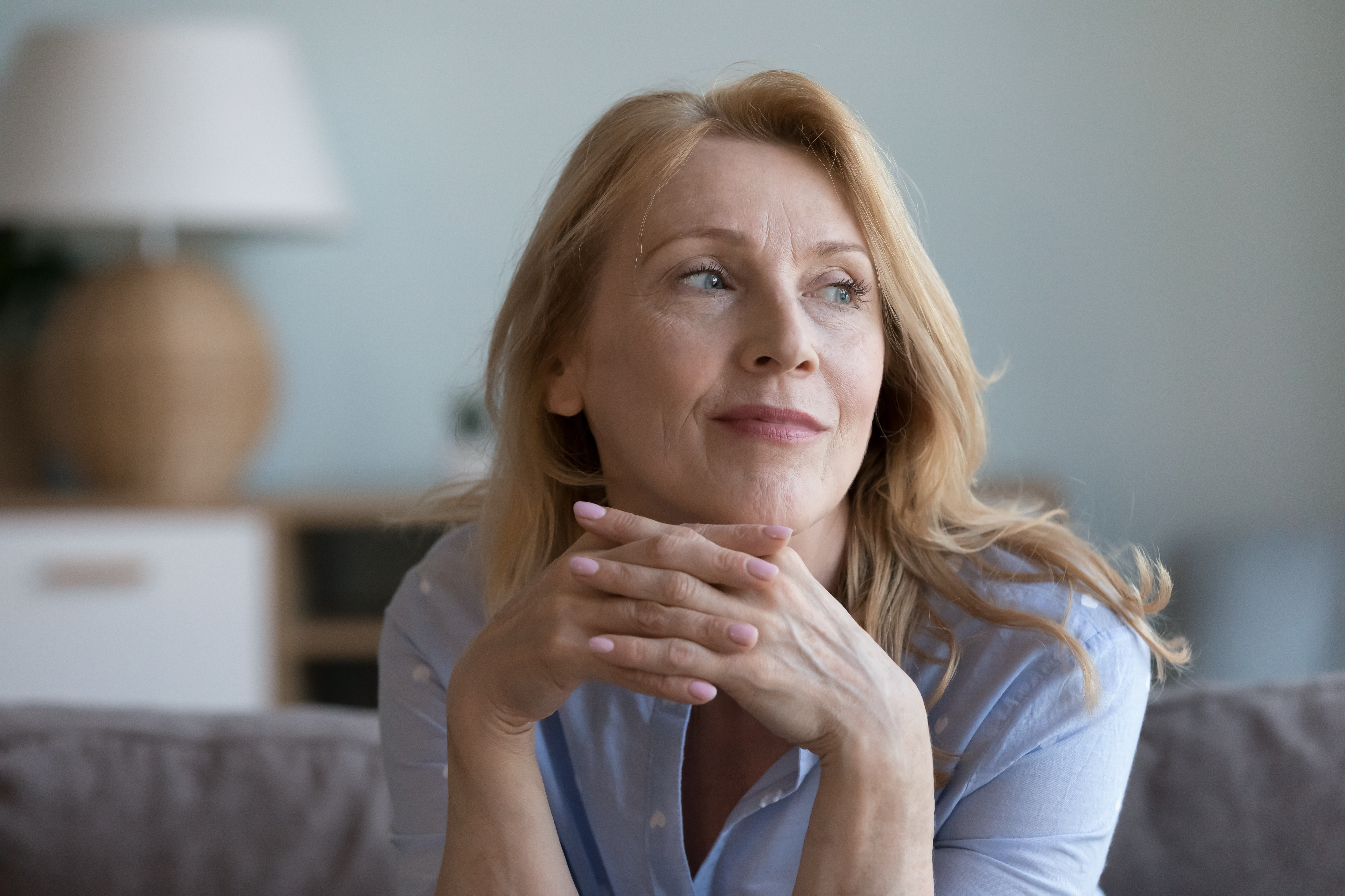 Attraktive Frau faltet die Hände vor dem Kinn
